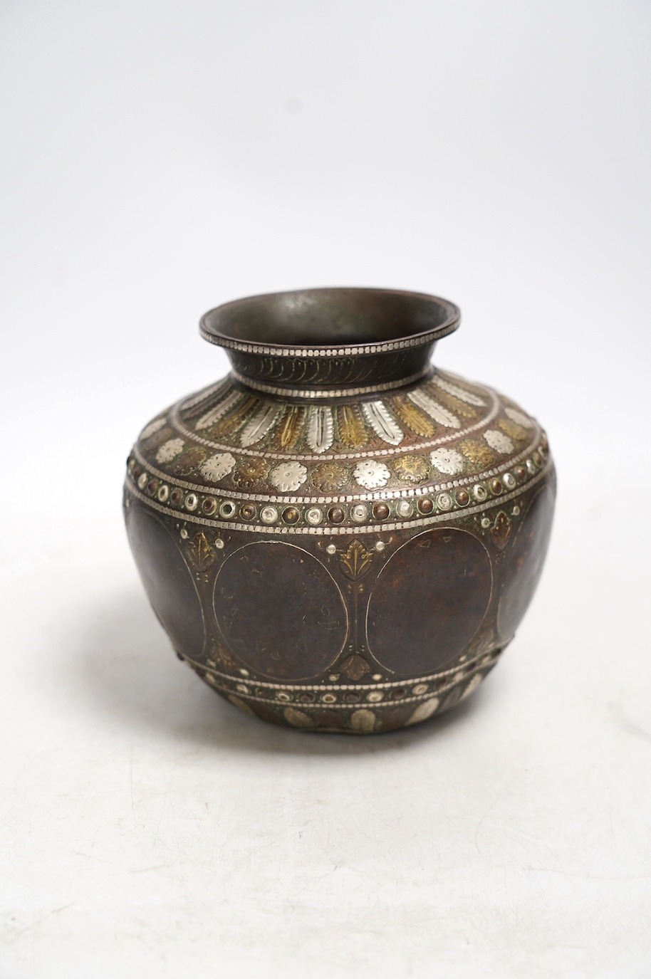 An Indian ganga jumna mixed metal water pot with engraved decoration, 14cm high. Condition - some dents